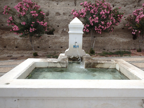 An old fountain trickles water around the area of the old church.